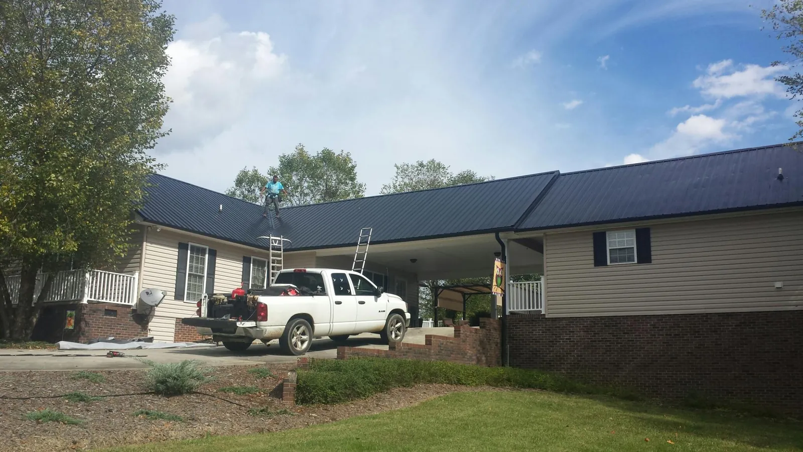 Black metal roof over a home and attached breezeway with ladders set in Baldwin