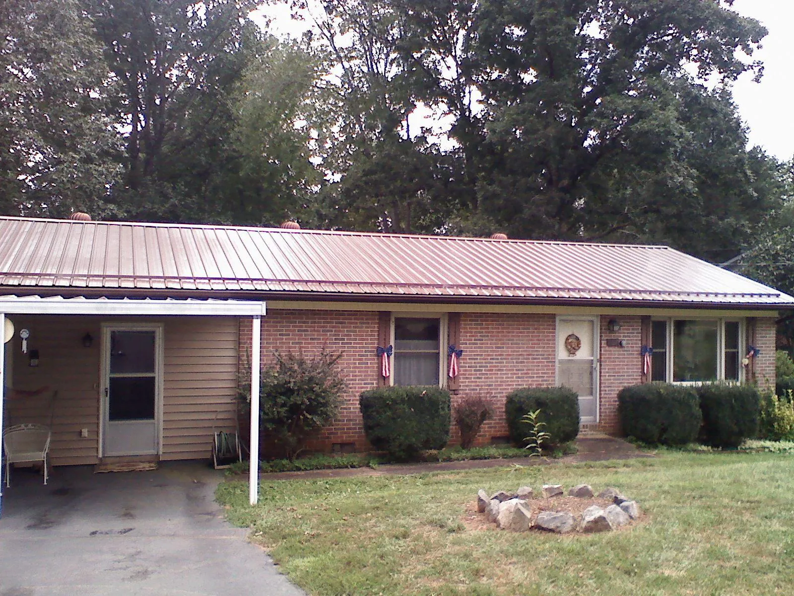 Bronze metal roof and carport on a brick ranch home — Roof Repair work by our crew in Baldwin